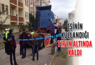 Eşinin kullandığı TIR'ın altında kaldı